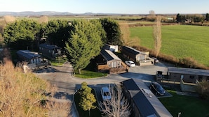 Un barrio residencial con varias casas, un camino de entrada y un gran campo verde al fondo.