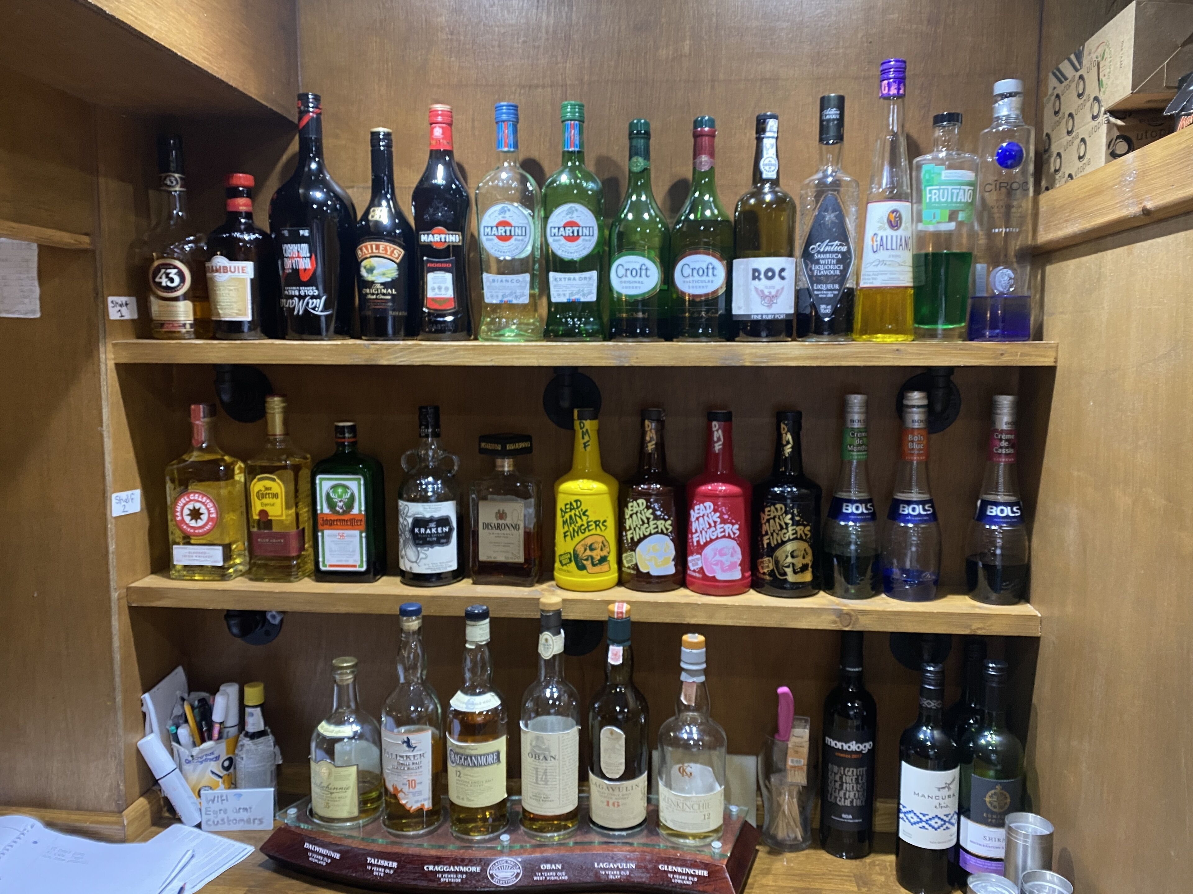 Une boutique de boissons alcoolisées dont les étagères sont remplies de différentes bouteilles d’alcool.