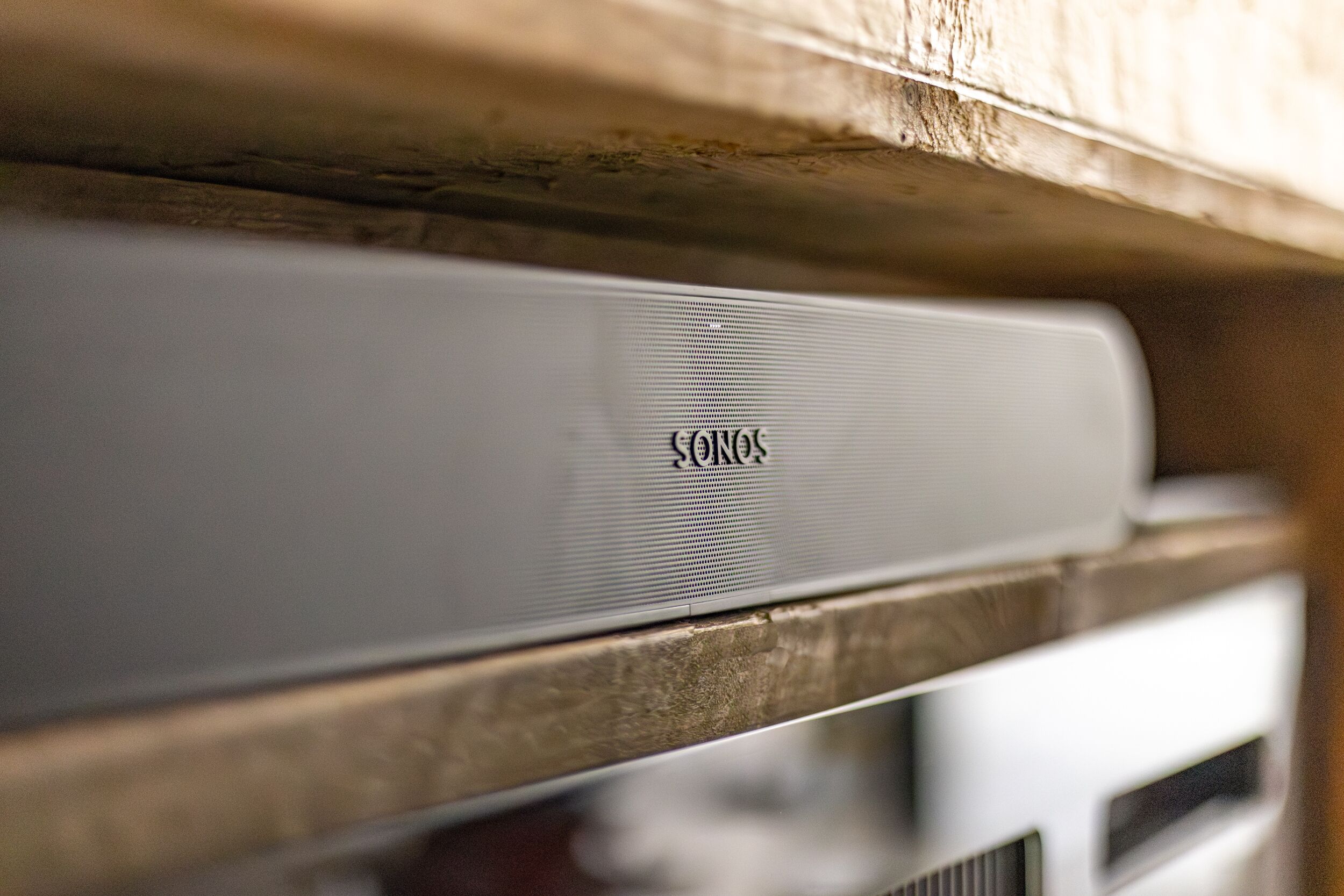 Un haut-parleur blanc portant la marque « SONY » et posé sur une surface en bois.