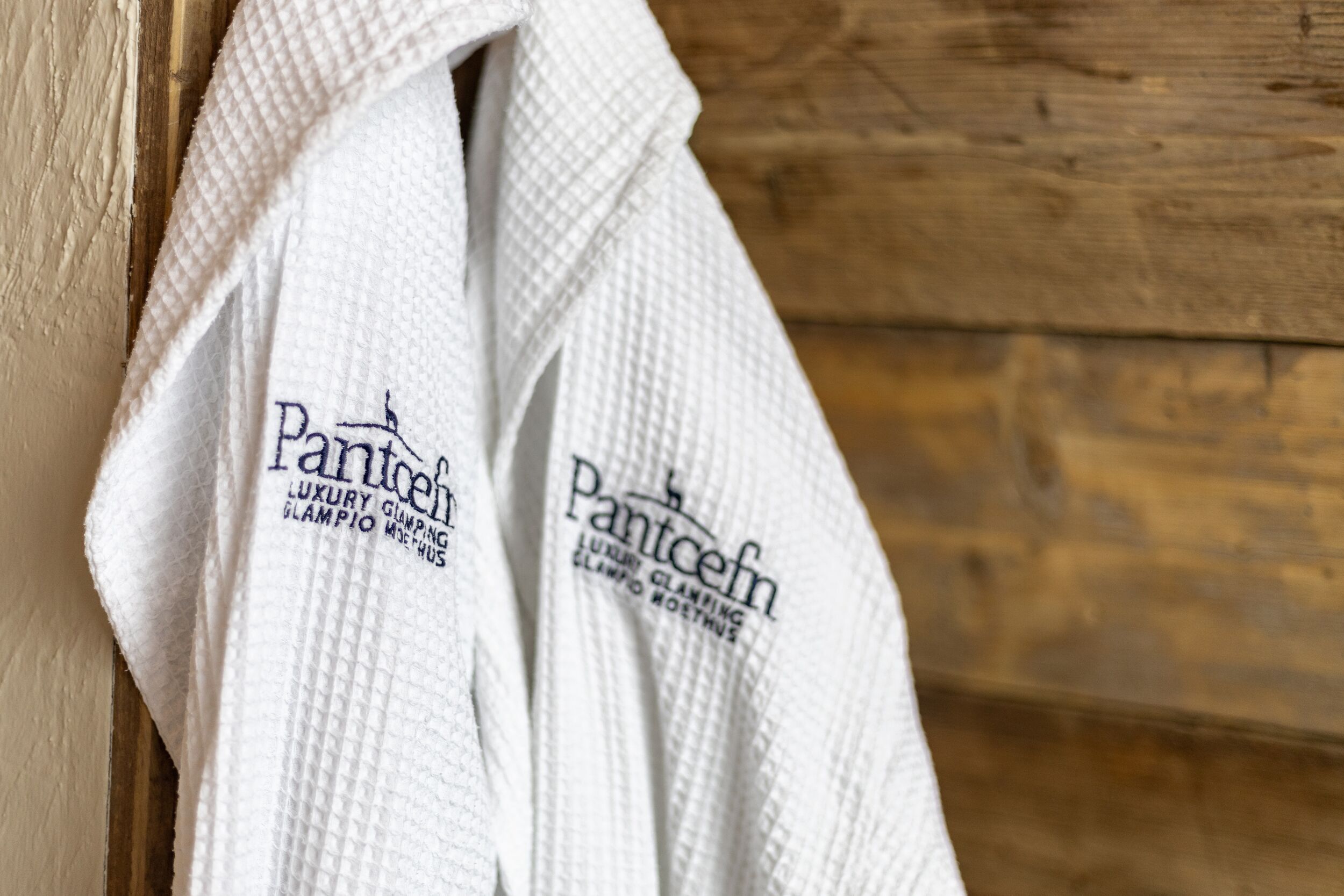 A white robe with the text "Pantcef" and "Luxury Climbing" on it.