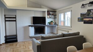 A modern living room with a fireplace, a television, and a sofa. - Green Heart Terrace - Newly renovated attic in the historic center of Narni (Narni)