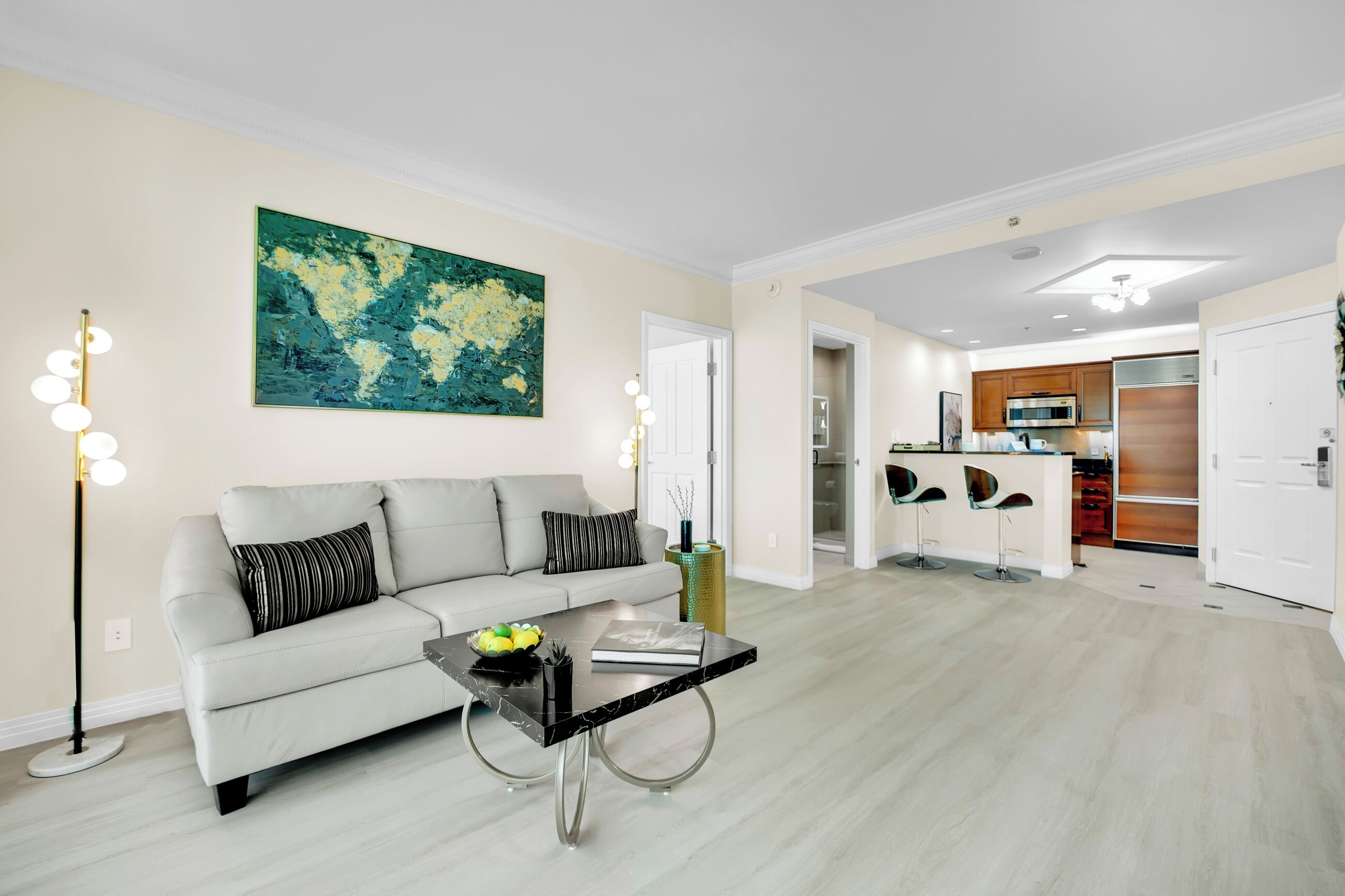 A modern living room with a sofa, coffee table, and a large abstract painting.