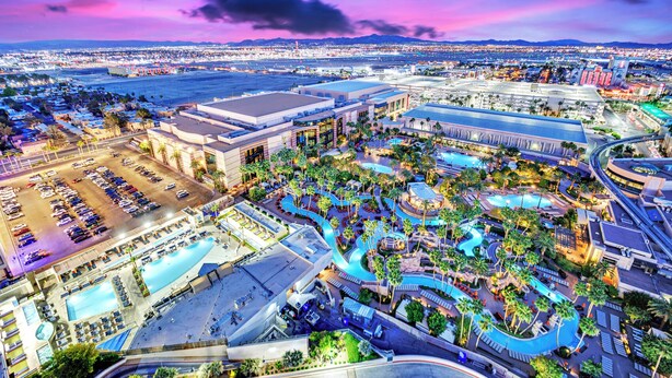 Un gran complejo hotelero con varias piscinas, un aparcamiento y vistas de la ciudad circundante.
