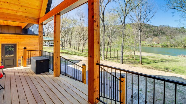 Una terraza de madera con vista a un río y árboles.