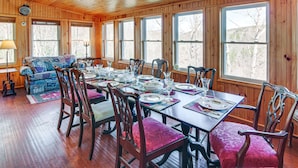 A wooden-paneled dining room with a long table set for six, surrounded by chairs with cushioned seats. - 8 Mi to Lake Lure! Mtn-View Gem w/ Furnished Deck (Rutherfordton)