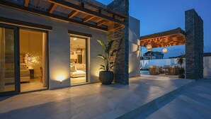 A modern house with a patio area, large windows, and a stone wall. - Experience life again at Soul Luxury Villa !  (Planos)