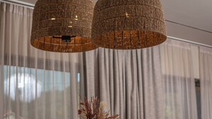 A dining area with a wooden table set for a meal, two woven pendant lights, and a vase with dried plants. - Experience life again at Soul Luxury Villa !  (Planos)