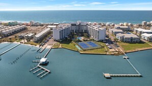 An aerial view of a coastal hotel with multiple buildings, a marina, and a tennis court. - Beach Access, Pool/Hot Tub, Sleeps 5 - Vet Owned (Gulf Shores)