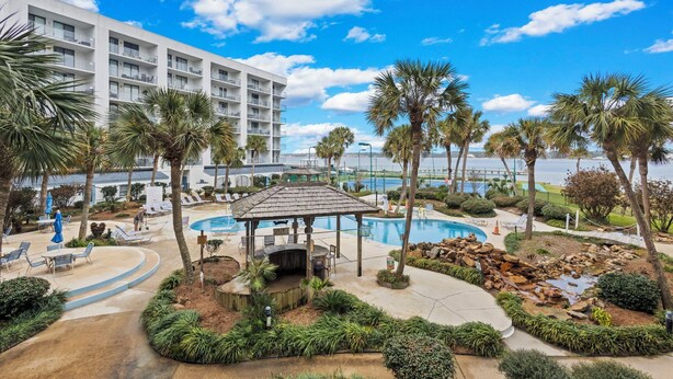 A resort with a pool area, palm trees, and a building with balconies. - Beach Access, Pool/Hot Tub, Sleeps 5 - Vet Owned (Gulf Shores)