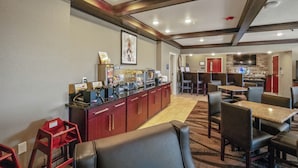 Eine Hotelhalle mit Kaffeebar, Sitzgelegenheiten und einer kleinen Küche.