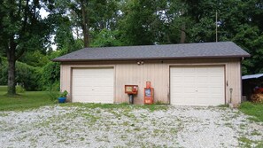 Un garage pour deux voitures, avec une allée en gravier et une boîte aux lettres.