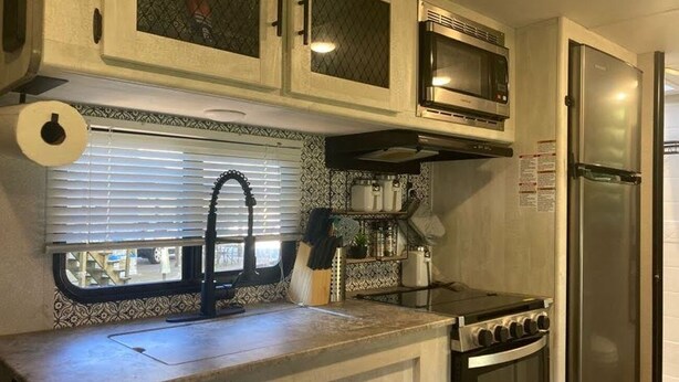 A kitchen with a stove, oven, microwave, and refrigerator. - Cozy Camper in Villa Ridge (Villa Ridge)