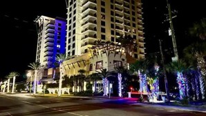 A multi-story hotel with balconies and a well-lit entrance. - Costal Condo - Ocean & Pool Views - Sleeps 6 (Panama City Beach)