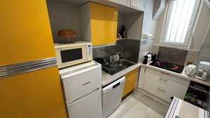 Une cuisine compacte équipée d’un four à micro-ondes, d’un évier et d’une machine à café.