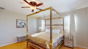 A four-poster canopy bed with a wooden frame and a ceiling fan. - King Beds Castle | Air Hockey | Room TVs | Firepit (Chico)