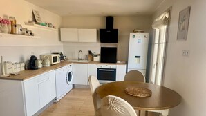 A compact kitchen with a washing machine, a dining table with chairs, and a refrigerator. - Beautiful view Walking distance from the center (Nice)