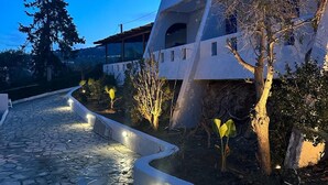 Un edificio moderno con un camino de piedra que conduce a una entrada protegida por una puerta.
