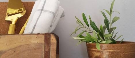 Une boîte en bois contenant une plante et une spatule de couleur dorée, posée sur une étagère.
