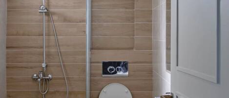 Une salle de bain moderne avec un lambris en bois, une douche, des toilettes et un lavabo.
