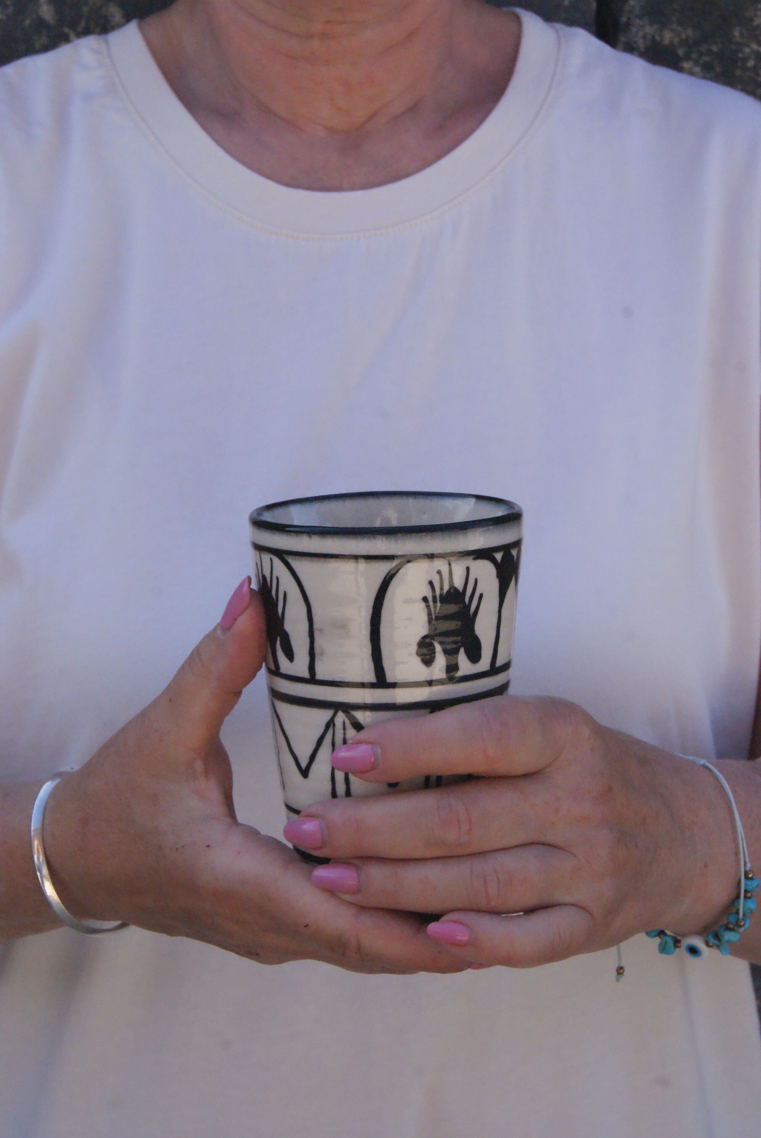 Una persona sosteniendo una taza con un diseño en blanco y negro.