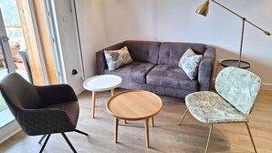 A modern living room with a leather sofa, two chairs, a small round table, and a floor lamp. - Beautiful, spacious apt near Arc 1600 (Bourg-Saint-Maurice)