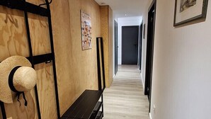 A hallway with wooden paneling, a bench, and framed artwork on the walls. - Beautiful, spacious apt near Arc 1600 (Bourg-Saint-Maurice)