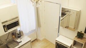 A compact kitchen with a microwave, coffee maker, and sink.
