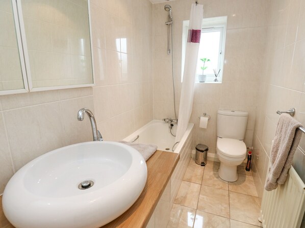 A bathroom with a sink, bathtub, toilet, and shower.