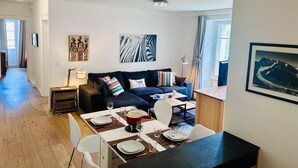 A modern living room with a sofa, dining table, and artwork on the walls. - Lovely flat in the heart of Chamonix (Chamonix-Mont-Blanc)
