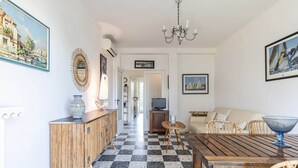 A dining area with a checkered floor, wooden table, and chairs. - In the heart of the Cap d'Antibes lovely flat (Antibes)