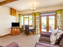 Una sala de estar acogedora con televisión, mueble de madera y un sofá.
