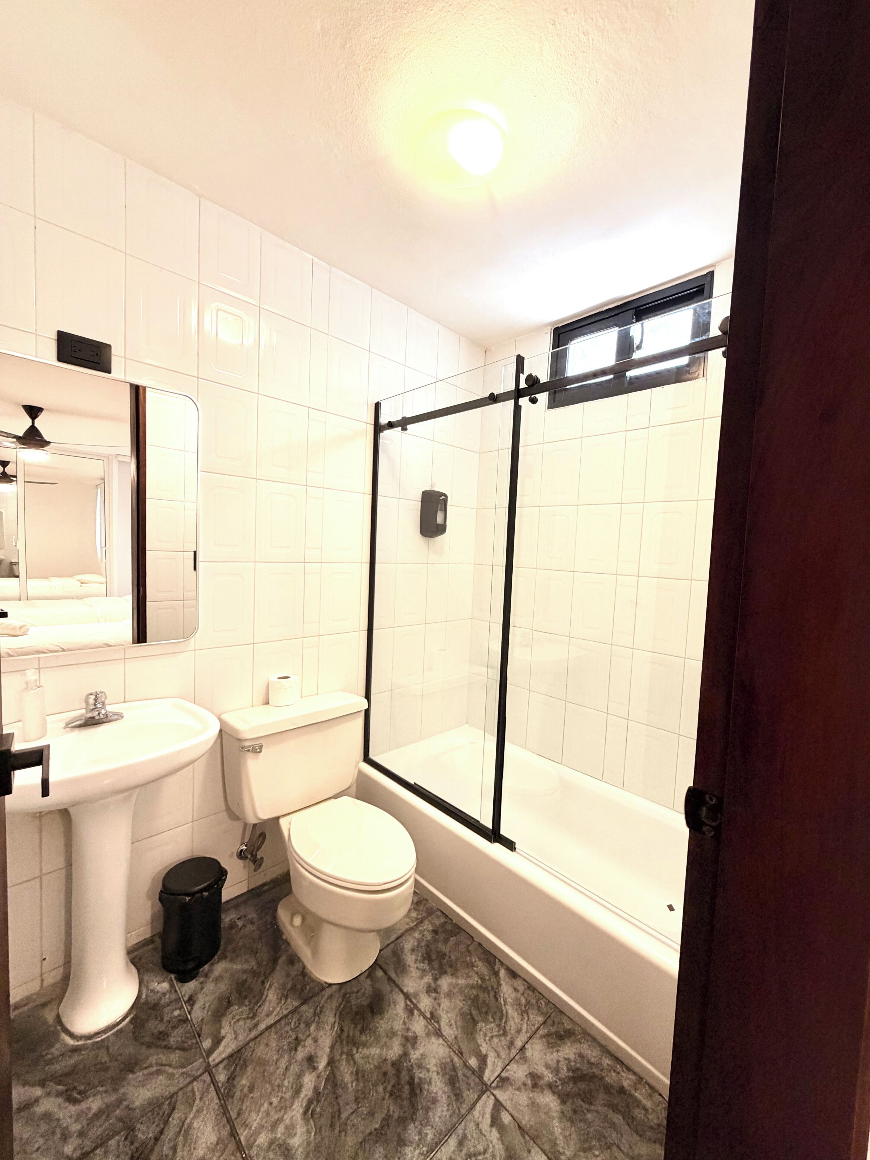 Un baño con inodoro, lavamanos y zona de ducha.