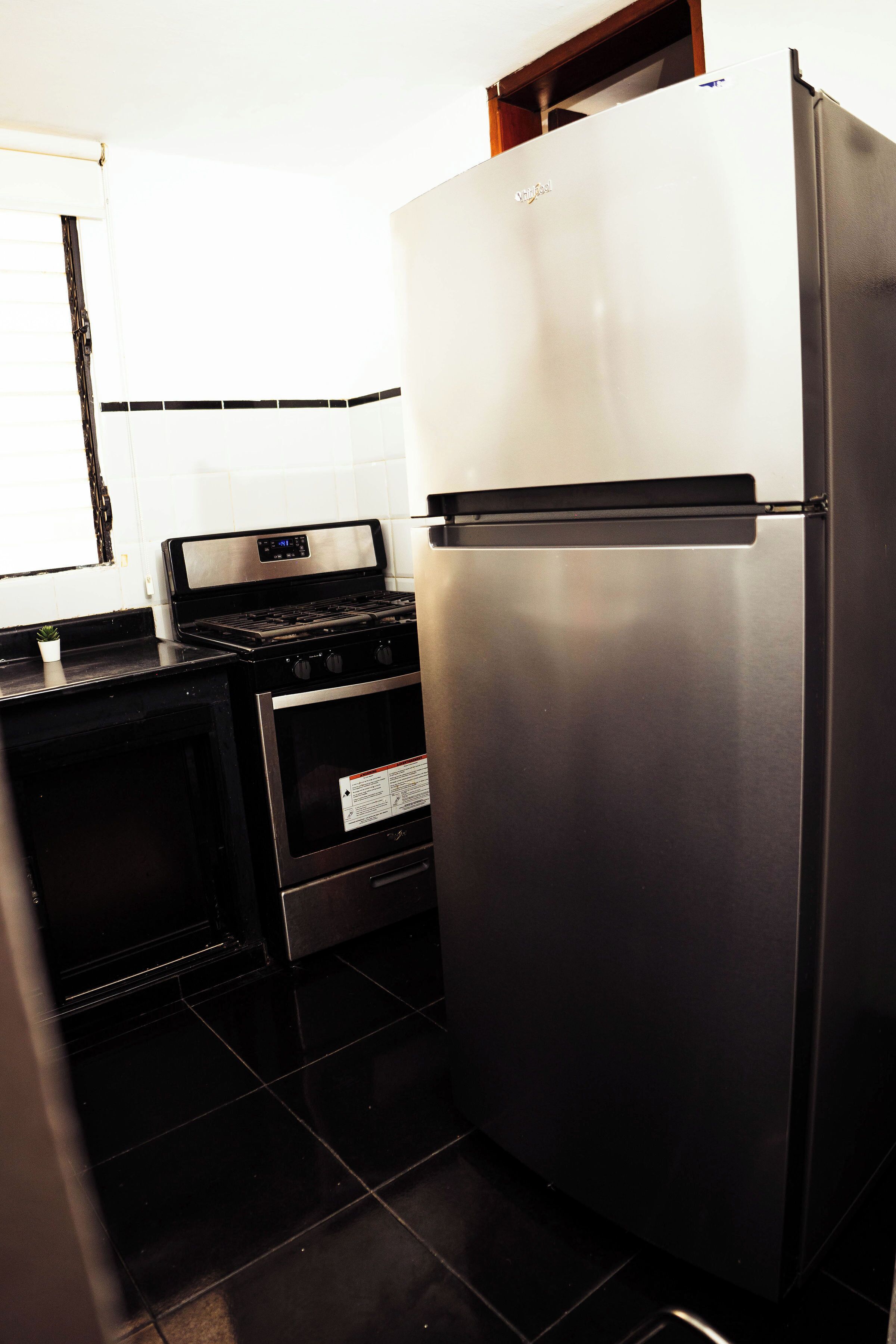 Une cuisine équipée d’un réfrigérateur, d’un four et d’une cuisinière en acier inoxydable.