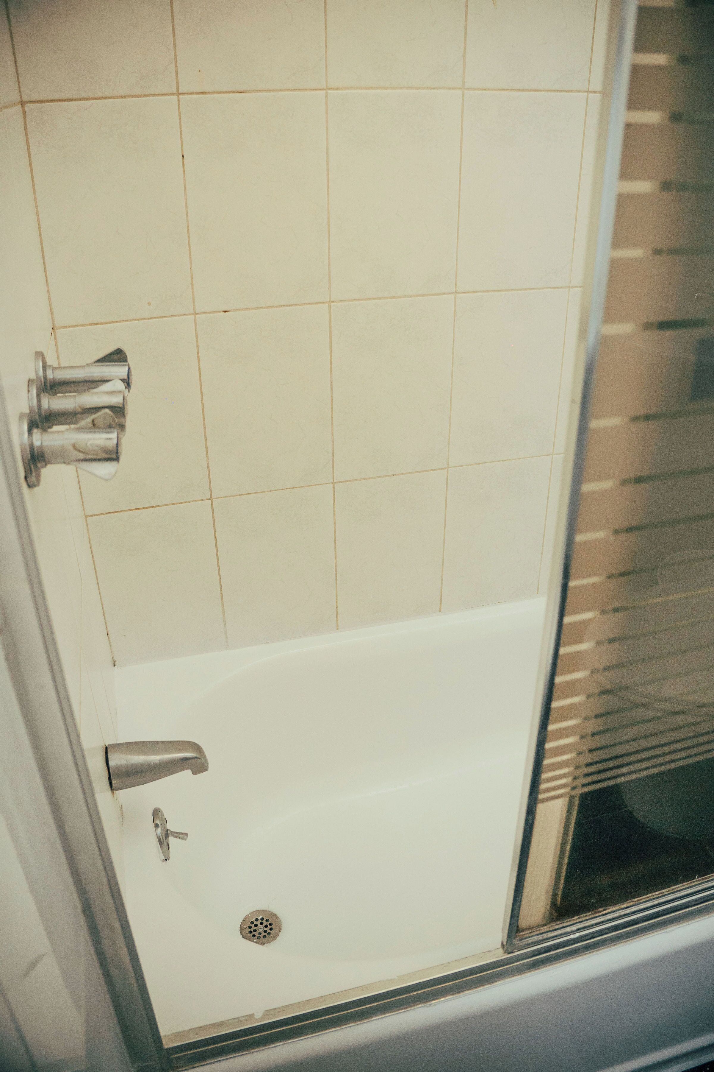 A bathroom with a shower, a toilet, and a sink.