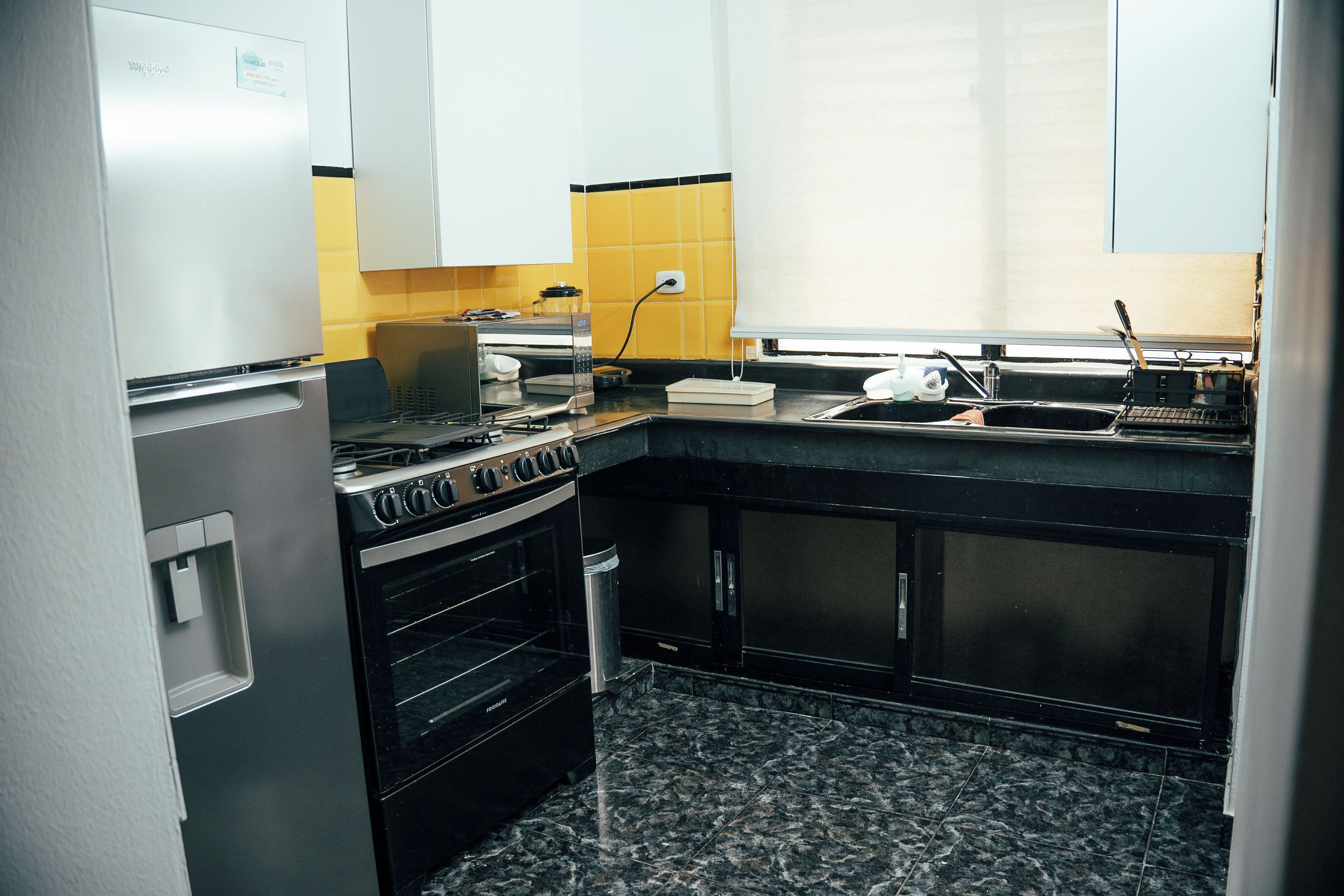 A compact kitchen with a stove, oven, and sink.