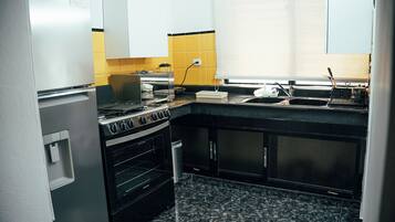 A compact kitchen with a stove, oven, and sink.