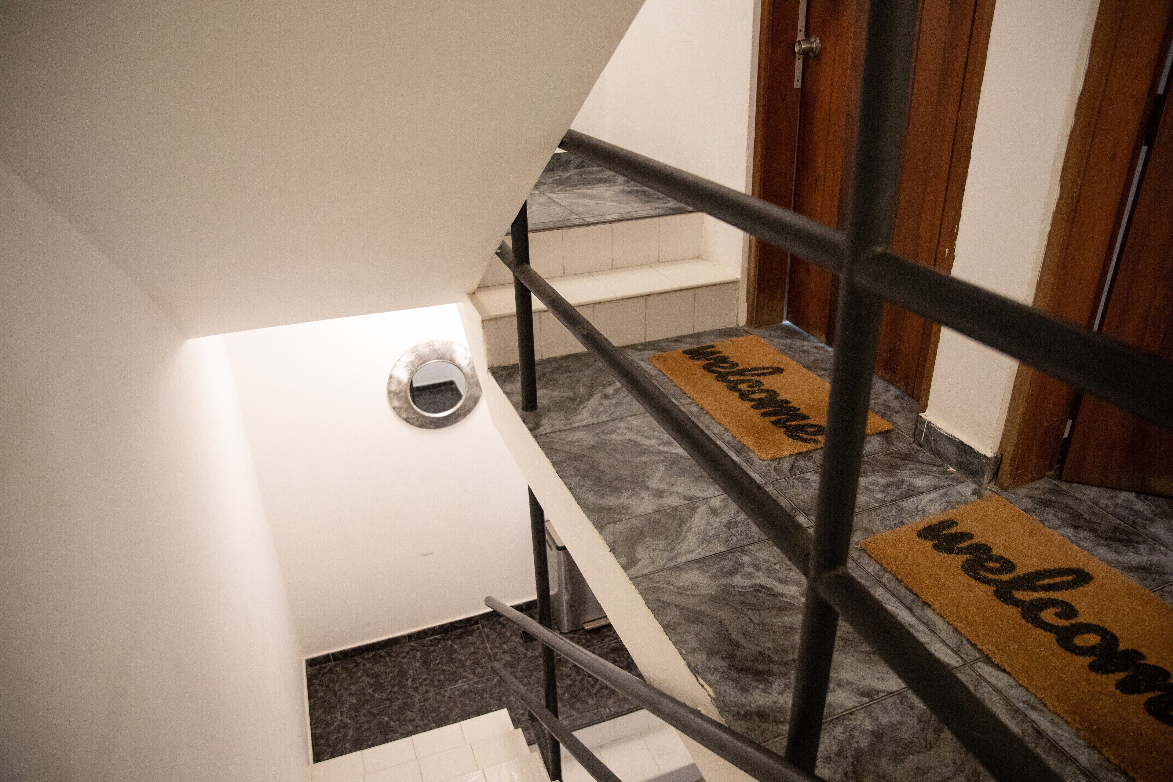 Una escalera con barandillas metálicas y un felpudo en la parte inferior.