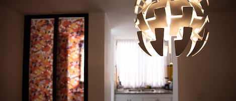Um interior moderno com uma luminária esférica e uma pintura abstrata colorida na parede.