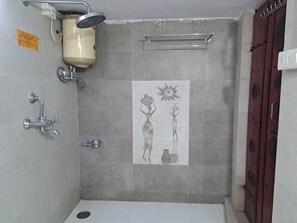A bathroom with a shower, a towel rack, and a toilet.