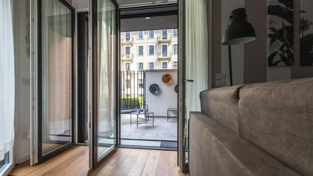 A modern living room with a sliding glass door leading to an outdoor balcony. - Italianway Comfort - Piranesi 18 B City Garden (Milan)