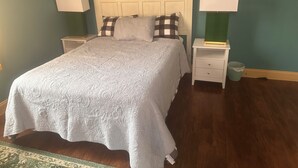 A neatly made bed with a white quilt, two bedside tables with lamps, and a green wall. - Luxury Downtown Condo (Clearfield)