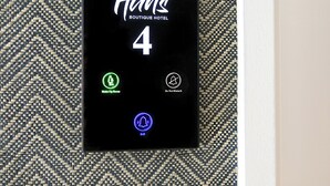 Digitaalinen huonekortti Hans Boutique -hotellin huoneeseen numero 4. Kortissa on kuvakkeet, jotka ilmaisevat, että huone on varattu meikkausta varten, huoneeseen ei saa mennä ja huonepalvelu on saatavilla.