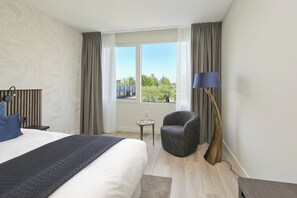 Habitación Confort doble, 1 cama de matrimonio grande, vistas a la ciudad | Colchones con acolchado adicional, minibar, caja fuerte y escritorio