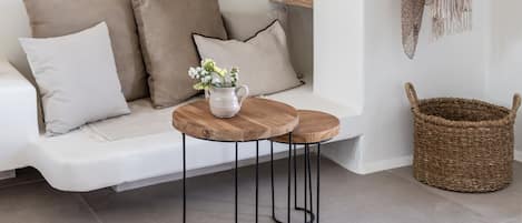 A modern living room with a white sofa, a small wooden table, and a woven basket.