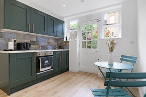 Estudio superior, baño en la habitación, vista al jardín | Cocina compartida | Horno, parrilla de estufa, tostadora y utensilios de cocina 