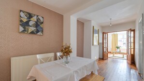 A room with a white table, a vase with flowers, a radiator, and a wooden floor. - Remarkable 3-bed House in Middleton Manchester (Manchester)