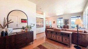 Un salon comprenant un canapé, une table basse, une lampe, un miroir et une cheminée.