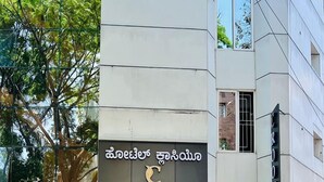 A modern building with a sign for 'Hotel Classic' in a foreign script. - Hotel Classio Kormangala (Bengaluru)