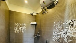 A bathroom with a toilet, shower, and a wall-mounted air conditioning unit. - Hotel Classio Kormangala (Bengaluru)