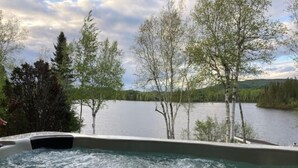 Una vasca idromassaggio con vista su un lago e alberi.